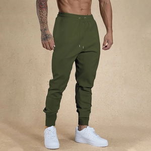 Detail of olive green slim fit joggers featuring drawstring waist and ribbed cuffs