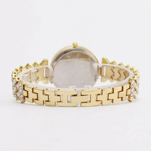 Back view of a gold fashion watch for women with rhinestone chain strap on a white stand