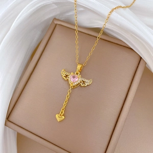 Goldene Titan-Halskette mit Herz-Anhänger, rosa Stein und Flügeln auf einer Schmuckbox
