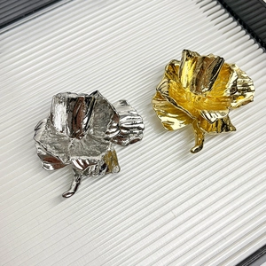 Vintage rose flower brooches in gold and silver finish set on a white textured background
