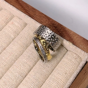 Detailed macro of gold and silver hammered texture rings in a wooden jewelry box