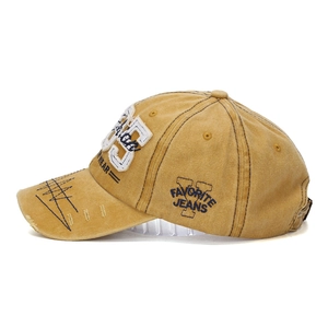 Close-up of mustard washed cotton baseball cap with vintage 1985 embroidery details
