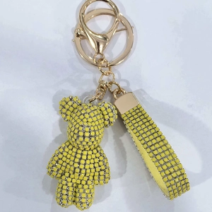Detailed view of a yellow rhinestone teddy bear keychain with matching wrist strap accessory