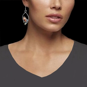 Vintage orange teardrop enamel earrings with silver trim shown on model for a retro look
