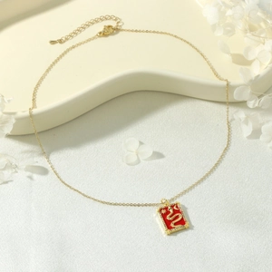 Macro detail of 18K gold snake tarot card necklace with red enamel and white silk