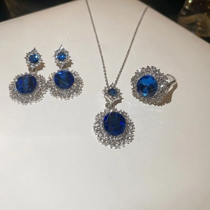 Detailed view of silver jewelry set featuring oval blue stones and crystal accents