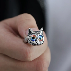 Macro detail of vintage cat ring featuring colorful galaxy eyes and silver textures