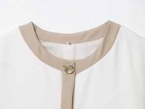 Detail of white blazer neckline with beige trim, gold button and size M label