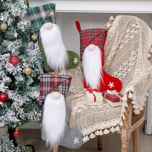 Three Christmas gnome stockings in green, red, and grey plaid patterns with plush details