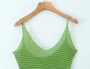 Dettaglio della trama in maglia all'uncinetto verde su un abito senza maniche traforato