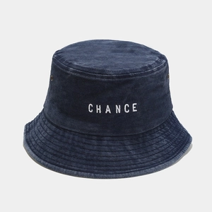 Detail of CHANCE embroidery on washed denim bucket hat with metal eyelets and stitching