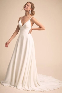 Detail of white chiffon wedding dress with thin straps and elegant long train