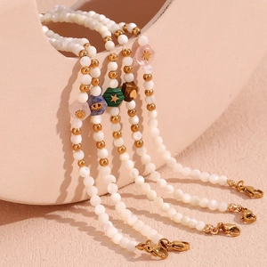 Close-up of hexagonal colorful stone charms on beaded necklaces with gold accents