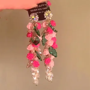 Handcrafted floral tassel earrings with pink resin flowers and green leaves on 925 silver pins