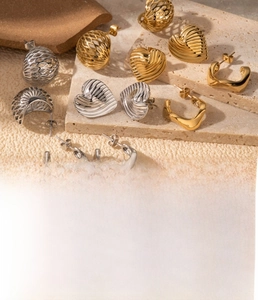 Detail of assorted heart and geometric stainless steel earrings in gold and silver finishes