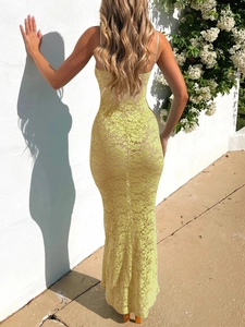 Vista posteriore del maxi abito attillato in pizzo giallo con dettagli cut-out