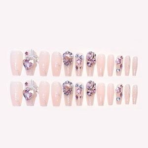Pink gradient press-on nails with purple crystals and silver bow decorations