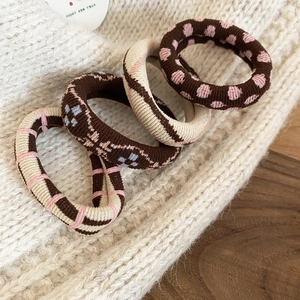Vue détaillée de quatre chouchous en maille vintage aux motifs floraux et à carreaux élégants