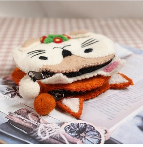 Detailed macro view of animal-shaped wool felt coin purses with zipper and pompom charm