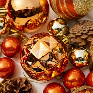 Golden and orange Christmas ornament set featuring faceted balls, pine cones, and glitter stars