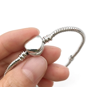 Classic silver snake chain bracelet featuring a heart-shaped clasp closure