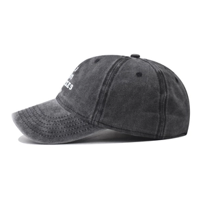 Detailed side view of washed charcoal grey cotton baseball cap with white embroidery