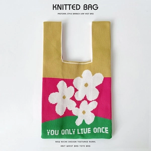 Detail of knitted bucket bag featuring floral pattern and YOU ONLY LIVE ONCE text