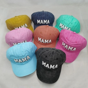 Pile of washed cotton baseball caps with MAMA embroidery in eight assorted colors