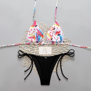 Detailed flat lay of bikini with fruit print halter top and black tie-side bottoms