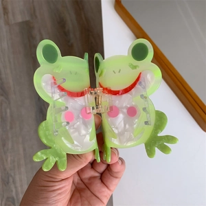 Detailaufnahme einer großen grünen Haarklammer in Froschform aus hochwertigem Acetat