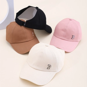 Détail de la lettre P brodée sur quatre casquettes en coton pour enfants