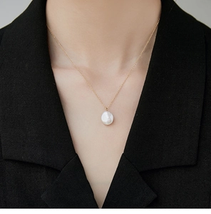 Detail van een witte zoetwaterparel hanger aan een 18K vergulde roestvrijstalen ketting voor