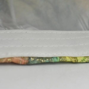 Macro shot of precise multi-row stitching on a colorful star print baseball cap