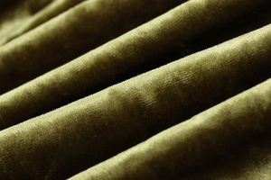 Macro shot of olive green velvet fabric showing soft texture and natural folds
