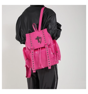 Detail of hot pink PU leather backpack with silver rivets and cross charm on model