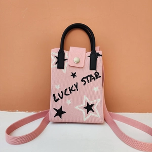 Close-up of pink knitted crossbody bag featuring Lucky Star pattern and silver snap