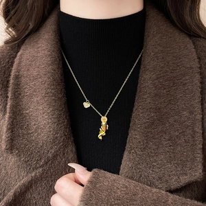 Detailansicht des 24k Gold Koi-Anhängers mit Zirkonia auf einem schwarzen Pullover