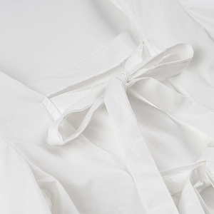 Détail du nœud papillon au dos du haut blanc avec manches bouffantes et col carré