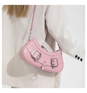 Close-up of pink crescent PU leather bag with glossy finish and silver buckle details