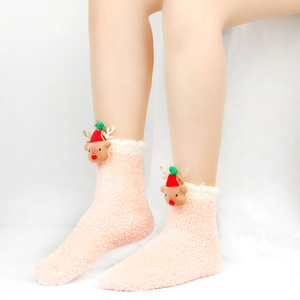 Nahaufnahme von rosa Korallenvlies-Socken mit süßen 3D-Rentier-Plüschfiguren am Saum