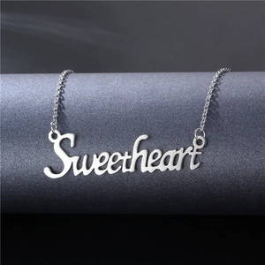 Collier prénom Sweetheart en acier poli présenté sur un support minimaliste sombre