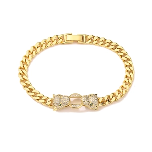 Macro detail of gold plated cuban chain bracelet featuring dual leopard heads with zircons