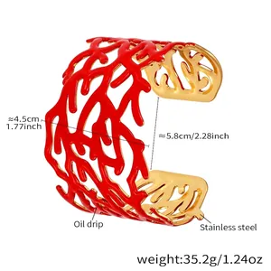 Détail du motif corail rouge évidé sur bracelet manchette large en acier plaqué or 18k