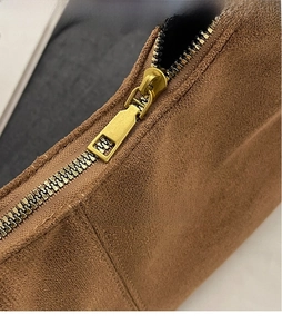 Close-up of golden metal zipper on vintage brown matte suede leather tote bag details