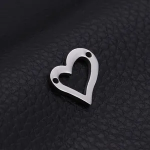 Polished silver stainless steel hollow heart pendant with dual holes on leather background