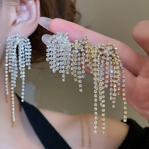 Detailed view of silver and gold sparkling fringe earrings with micro-set rhinestones