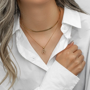 Double layer gold snake chain necklace with pearl letter R pendant on model wearing white shirt