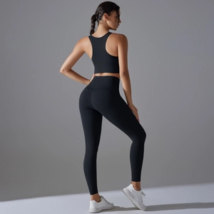 Detailansicht der schwarzen High-Waist-Yogahose und des Racerback-Sport-BHs am Model