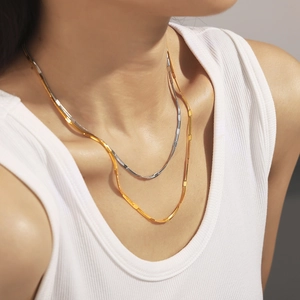 Layered gold and silver stainless steel herringbone chain necklace on female model