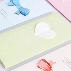 Three-fold greeting cards with 3D paper heart and bow designs in pastel colors